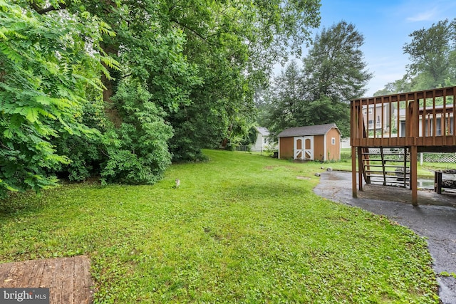1157 Pine Tree Dr, Annapolis, MD 21409 - view of grassy yard featuring a storage shed, a wooden deck, and stairway