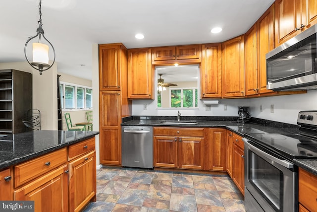 1157 Pine Tree Dr, Annapolis, MD 21409 - kitchen with stainless steel appliances, brown cabinets, ceiling fan, stone finish floors, and pendant lighting