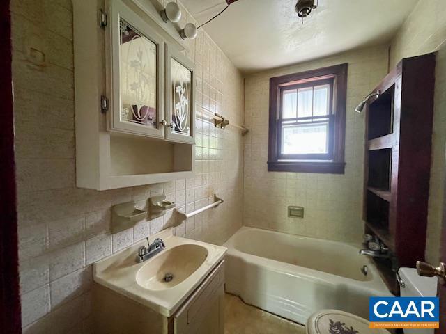 24 E 1st St, Craigsville, VA 24430 - full bathroom with tile walls, vanity, toilet, backsplash, and shower / tub combination