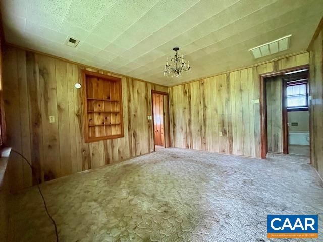 24 E 1st St, Craigsville, VA 24430 - carpeted spare room featuring wood walls and a chandelier