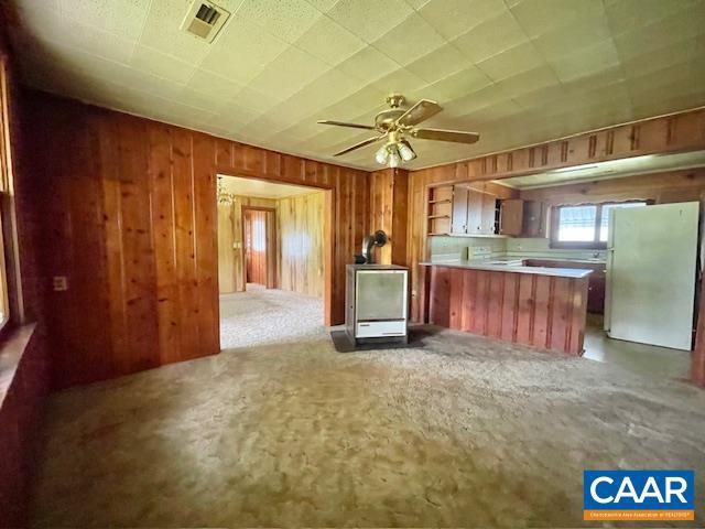 24 E 1st St, Craigsville, VA 24430 - kitchen featuring freestanding refrigerator, light carpet, wooden walls, a peninsula, and a ceiling fan