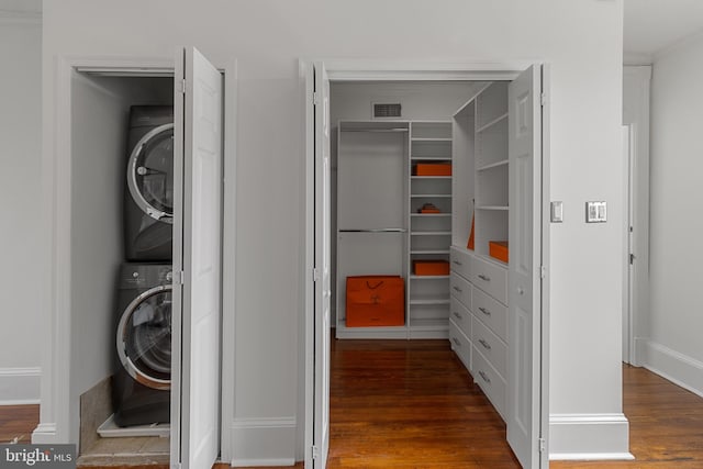 3551 13th St NW, Washington, DC 20010 - laundry area featuring stacked washer and clothes dryer, wood finished floors, and baseboards