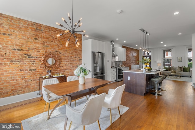 3551 13th St NW, Washington, DC 20010 - dining room featuring a chandelier, brick wall, wood finished floors, recessed lighting, and baseboards