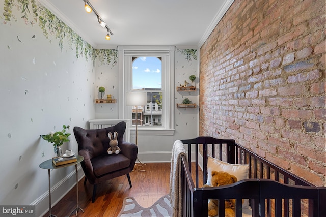 3551 13th St NW, Washington, DC 20010 - bedroom featuring baseboards, ornamental molding, hardwood / wood-style floors, and brick wall