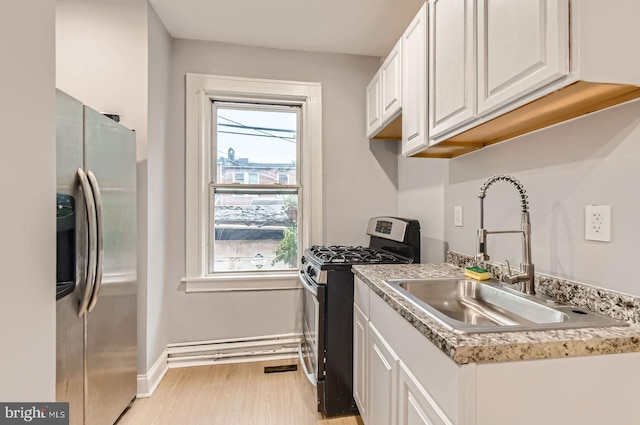 4158 Eierman Ave, Baltimore, MD 21206 - kitchen with stainless steel appliances, a sink, white cabinetry, light wood-type flooring, and baseboards