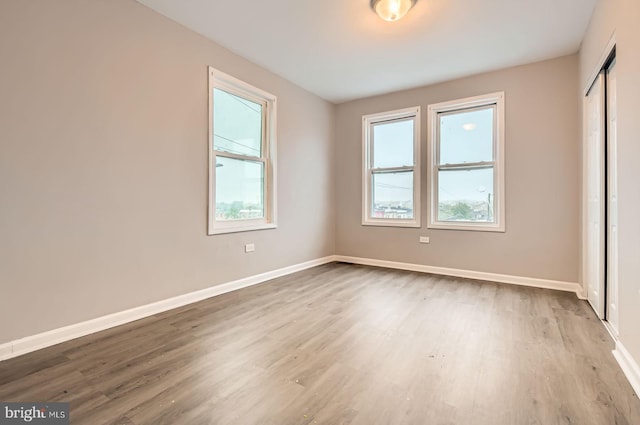 4158 Eierman Ave, Baltimore, MD 21206 - unfurnished bedroom featuring multiple windows, wood finished floors, and baseboards