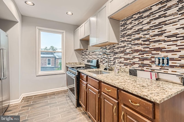 4158 Eierman Ave, Baltimore, MD 21206 - kitchen featuring appliances with stainless steel finishes, a sink, backsplash, light stone counters, and white cabinetry