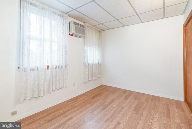 105 Ann St, Duncannon, PA 17020 - unfurnished room with a wall mounted air conditioner, light wood-style floors, a drop ceiling, and baseboards