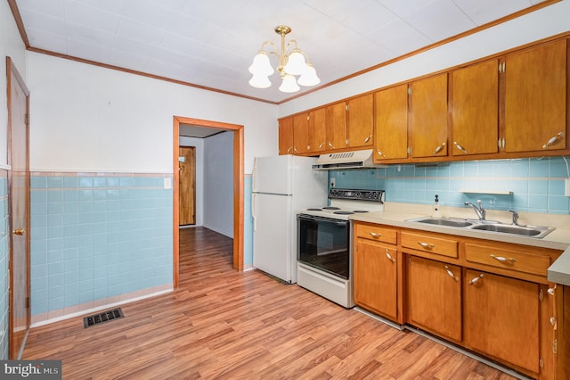 105 Ann St, Duncannon, PA 17020 - kitchen with electric stove, freestanding refrigerator, a chandelier, light wood-style flooring, and light countertops