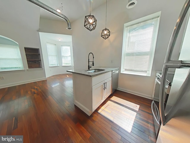 3228 W Diamond St, Philadelphia, PA 19121 - kitchen featuring light stone counters, appliances with stainless steel finishes, dark wood-type flooring, white cabinetry, and pendant lighting