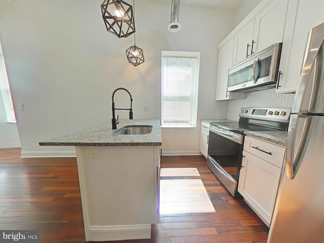 3228 W Diamond St, Philadelphia, PA 19121 - kitchen with appliances with stainless steel finishes, dark wood finished floors, light stone counters, decorative backsplash, and white cabinetry