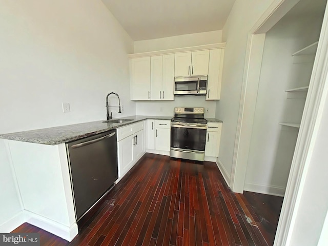 3228 W Diamond St, Philadelphia, PA 19121 - kitchen featuring appliances with stainless steel finishes, dark stone counters, dark wood-style flooring, and white cabinetry