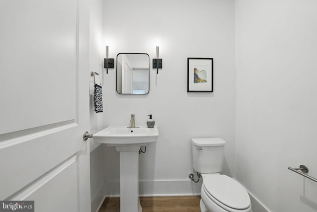 17941 Woods Overlook Dr, Dumfries, VA 22026 - half bathroom featuring toilet, baseboards, wood finished floors, and a sink