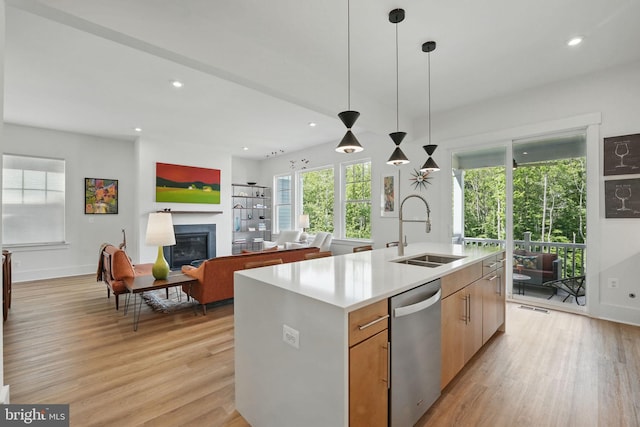 17941 Woods Overlook Dr, Dumfries, VA 22026 - kitchen with stainless steel dishwasher, a sink, light wood-style floors, a glass covered fireplace, and recessed lighting