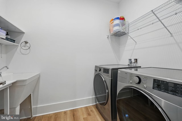 17941 Woods Overlook Dr, Dumfries, VA 22026 - washroom with washing machine and clothes dryer, light wood finished floors, and baseboards