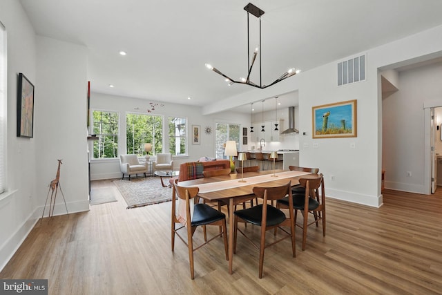 17941 Woods Overlook Dr, Dumfries, VA 22026 - dining space with light wood finished floors, baseboards, a chandelier, and recessed lighting