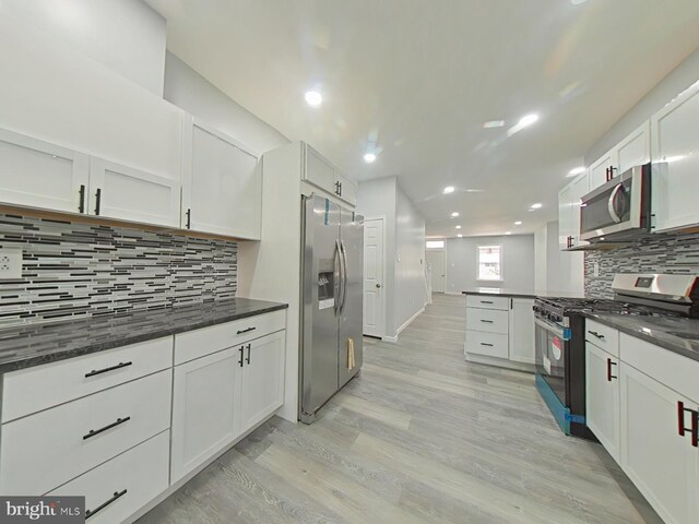 134 N Hobart St, Philadelphia, PA 19139 - kitchen featuring stainless steel appliances, backsplash, light wood-style flooring, recessed lighting, and white cabinets