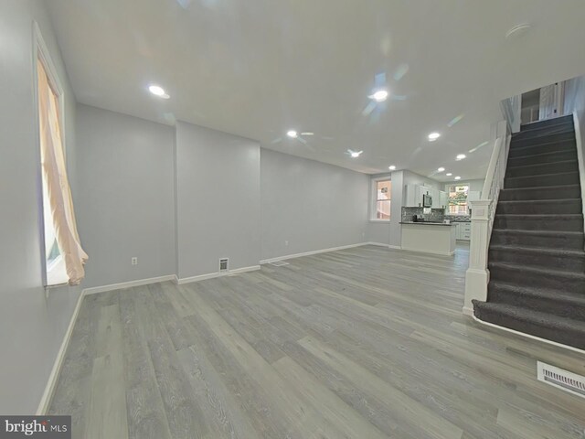 134 N Hobart St, Philadelphia, PA 19139 - unfurnished living room with baseboards, light wood-type flooring, recessed lighting, and stairs