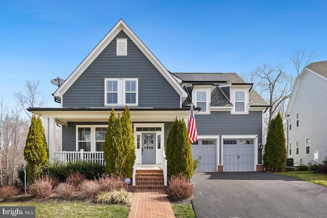 2305 Harmsworth Dr, Dumfries, VA 22026 - view of front facade with asphalt driveway, a porch, roof mounted solar panels, and an attached garage