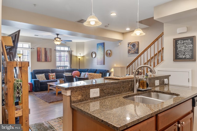 7136 Daniel John Dr, Elkridge, MD 21075 - kitchen with hanging light fixtures, open floor plan, wood finished floors, brown cabinetry, and recessed lighting