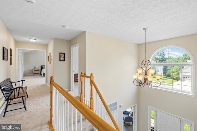1104 Century Oak Dr, Fredericksburg, VA 22401 - hall featuring a chandelier, an upstairs landing, light colored carpet, and a textured ceiling