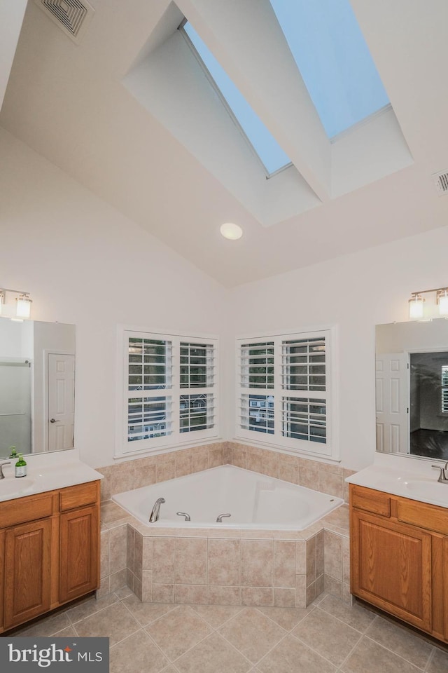 1421 Pickett Ct, Front Royal, VA 22630 - bathroom featuring a skylight, a tub with jets, two vanities, tile patterned floors, and high vaulted ceiling