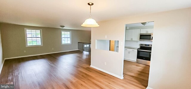 3 New Coach Ln, Willingboro, NJ 08046 - kitchen featuring stainless steel appliances, light wood-style flooring, white cabinets, baseboards, and hanging light fixtures