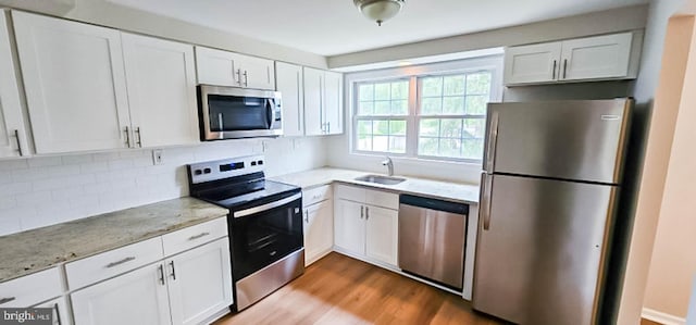 3 New Coach Ln, Willingboro, NJ 08046 - kitchen with appliances with stainless steel finishes, white cabinets, and light stone counters
