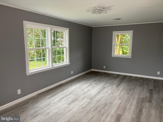 unfurnished room featuring ornamental molding, baseboards, wood finished floors, and a ceiling fan