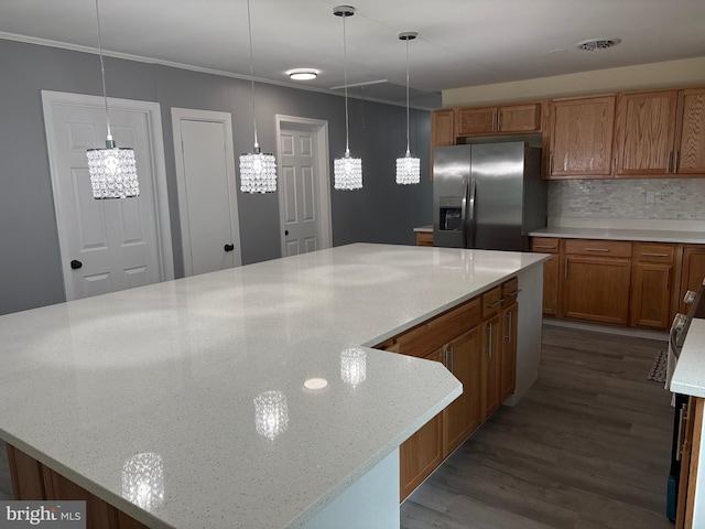 kitchen featuring stainless steel fridge with ice dispenser, brown cabinetry, dark wood-style flooring, tasteful backsplash, and light stone countertops