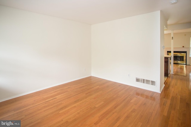 40 Ashley Dr, New Castle, DE 19720 - empty room featuring light wood-style floors, baseboards, and a multi sided fireplace
