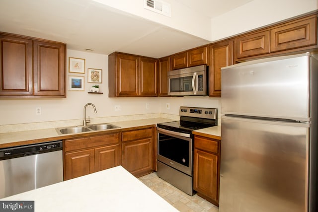 40 Ashley Dr, New Castle, DE 19720 - kitchen featuring stainless steel appliances, a sink, and brown cabinets