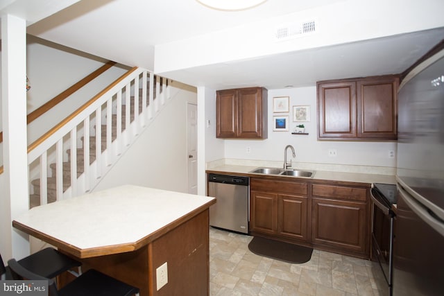 40 Ashley Dr, New Castle, DE 19720 - kitchen featuring a sink, stainless steel appliances, a breakfast bar area, light countertops, and a peninsula