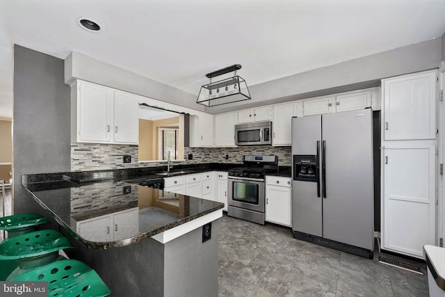 12329 Manchester Way, Woodbridge, VA 22192 - kitchen with stainless steel appliances, a peninsula, decorative backsplash, and white cabinetry