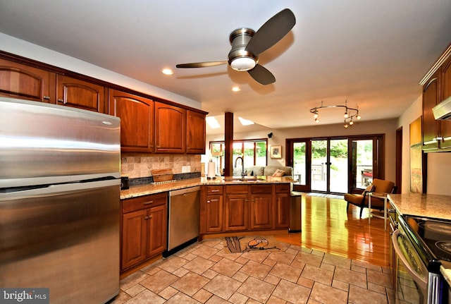 2415 Schaffer Rd, Pottstown, PA 19464 - kitchen featuring appliances with stainless steel finishes, a sink, a ceiling fan, decorative backsplash, and light stone counters