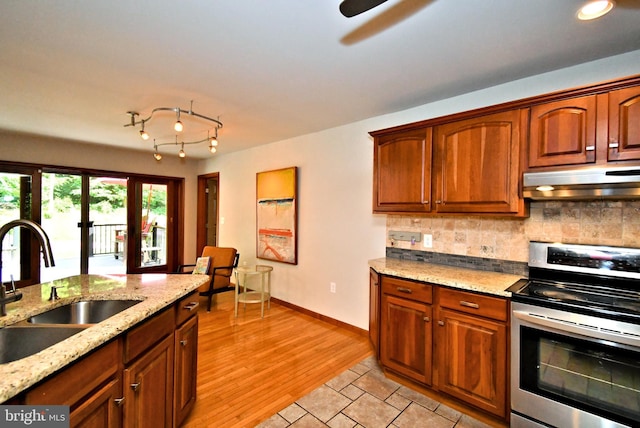2415 Schaffer Rd, Pottstown, PA 19464 - kitchen with stainless steel electric range, under cabinet range hood, a sink, tasteful backsplash, and light wood-style floors