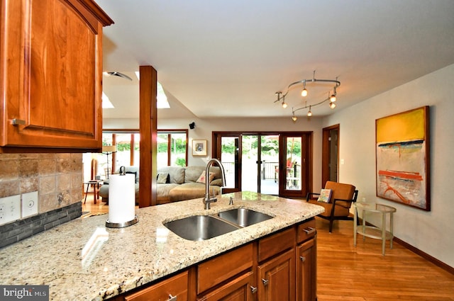 2415 Schaffer Rd, Pottstown, PA 19464 - kitchen featuring a sink, light stone countertops, wood finished floors, open floor plan, and brown cabinets