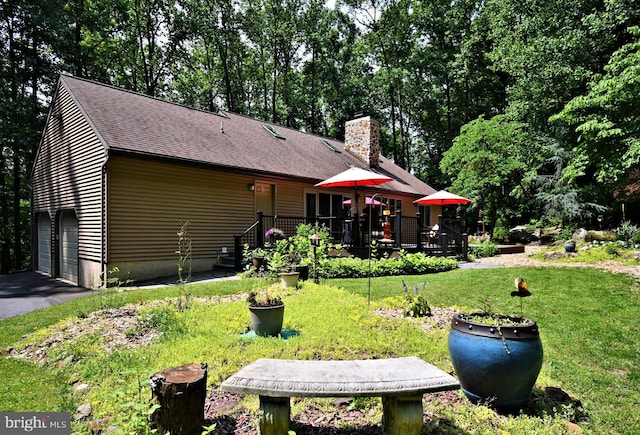 2415 Schaffer Rd, Pottstown, PA 19464 - rear view of house with a garage, a shingled roof, a chimney, a lawn, and a deck