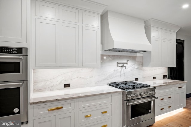 934 Chesterfield Rd, Annapolis, MD 21401 - kitchen with stainless steel appliances, premium range hood, white cabinets, and backsplash