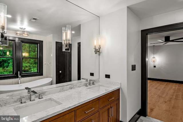 934 Chesterfield Rd, Annapolis, MD 21401 - full bathroom featuring double vanity, a soaking tub, wood finished floors, and a ceiling fan