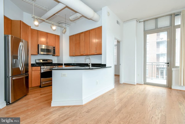 4490 Market Commons Dr Unit 302, Fairfax, VA 22033 - kitchen with stainless steel appliances, dark countertops, a sink, and light wood-style flooring