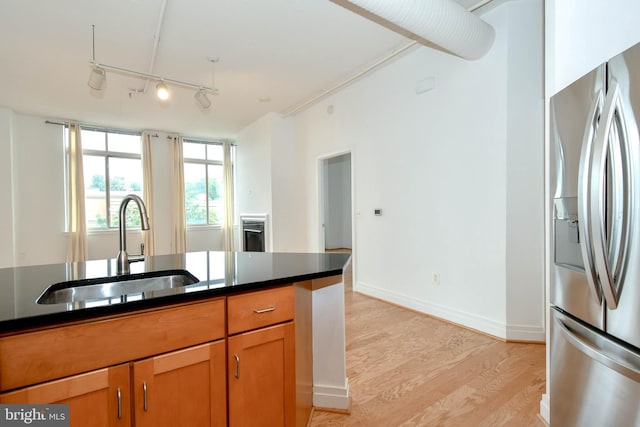 4490 Market Commons Dr Unit 302, Fairfax, VA 22033 - kitchen featuring stainless steel fridge, a sink, dark countertops, light wood-type flooring, and brown cabinetry