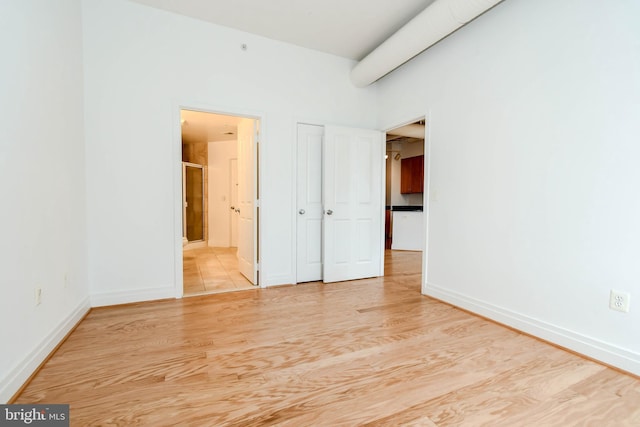 4490 Market Commons Dr Unit 302, Fairfax, VA 22033 - unfurnished bedroom with baseboards, wood finished floors, and connected bathroom