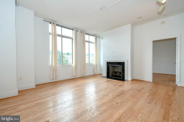 4490 Market Commons Dr Unit 302, Fairfax, VA 22033 - unfurnished living room featuring a fireplace with flush hearth, light wood-style floors, and baseboards