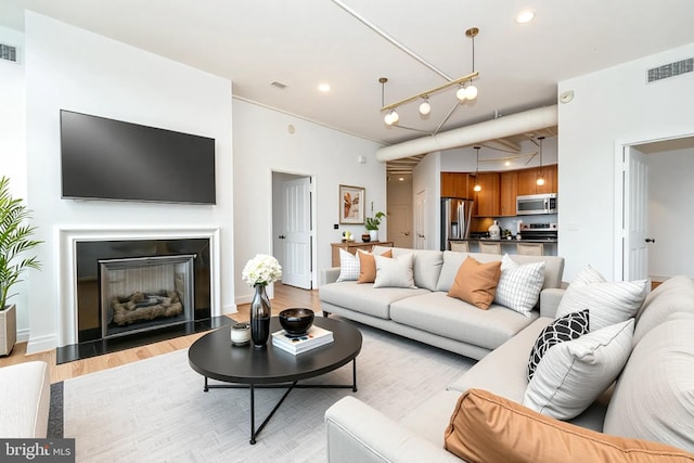 4490 Market Commons Dr Unit 302, Fairfax, VA 22033 - living area with light wood-type flooring, a fireplace with flush hearth, and recessed lighting