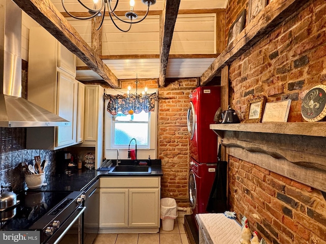 120 S Water St, Charles Town, WV 25414 - kitchen featuring a chandelier, a sink, estacked washer and dryer, stainless steel dishwasher, and brick wall