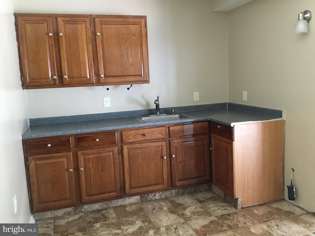 24 Galt Way, Stafford, VA 22554 - kitchen featuring a sink, dark countertops, stone finish flooring, and brown cabinets