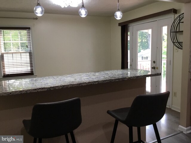 24 Galt Way, Stafford, VA 22554 - kitchen featuring light stone countertops, decorative light fixtures, a kitchen bar, and baseboards