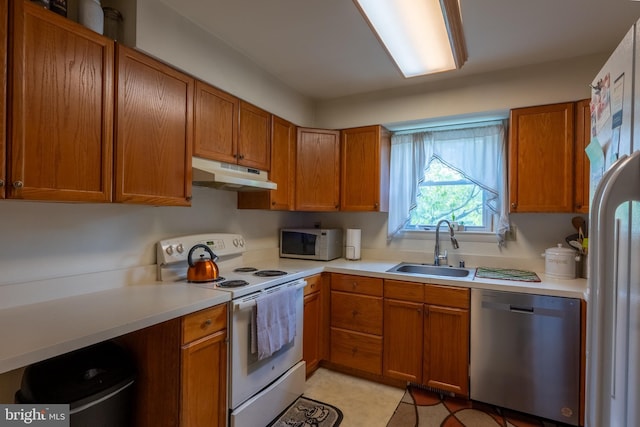 419 S Wyomissing Ave, Reading, PA 19607 - kitchen featuring white appliances, under cabinet range hood, a sink, light countertops, and brown cabinetry