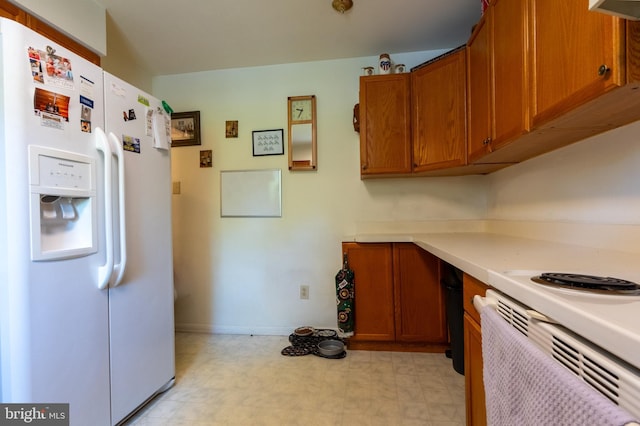 419 S Wyomissing Ave, Reading, PA 19607 - kitchen featuring white fridge with ice dispenser, light floors, brown cabinetry, light countertops, and baseboards